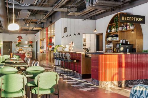 un restaurante con sillas verdes y un bar en Best Western Plus Hotel Kungens Kurva, en Estocolmo