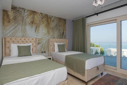 a bedroom with two beds and a view of the ocean at BEACH FRONT SUPER VİLLA Boss 2 in Bodrum City