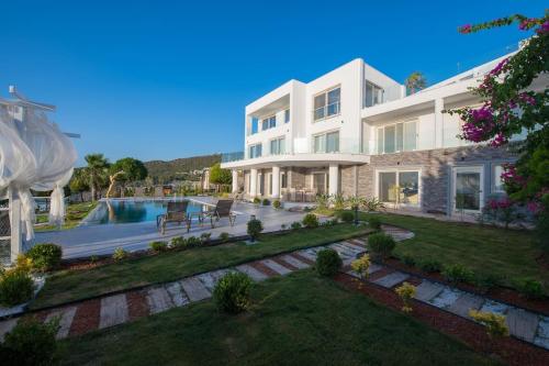 een groot huis met een zwembad en een tuin bij BEACH FRONT SUPER VİLLA Boss 2 in Bodrum City