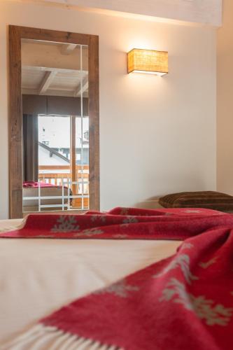 a bedroom with two beds and a mirror and a window at Olimpia Hotel in Bormio