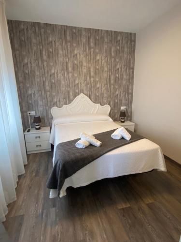 a bedroom with a bed with two towels on it at HOSPEDAJE STOP in Corrubedo