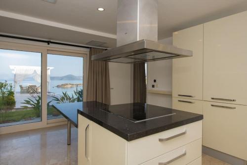 een keuken met een eiland en een kookplaat. bij BEACH FRONT SUPER VİLLA Boss 2 in Bodrum City