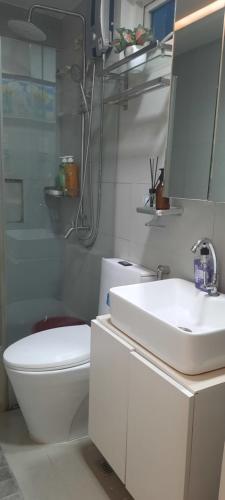 a bathroom with a sink and a toilet and a mirror at Mariz Cozy and Elegant room in Manila