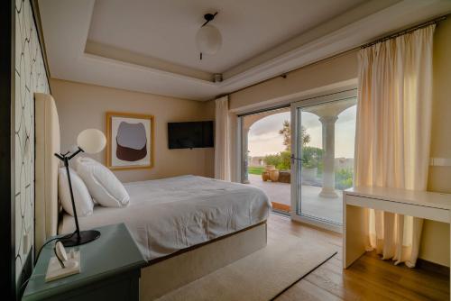 een slaapkamer met een bed en een glazen schuifdeur bij Villa de lujo con piscina y vistas al mar in Tacoronte