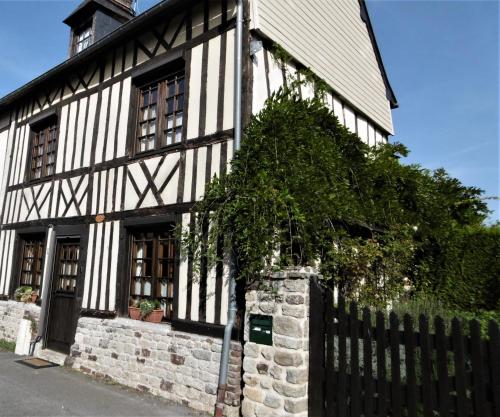 a black and white building with a tree in front of it at Holiday House/Gîte in Gaillefontaine