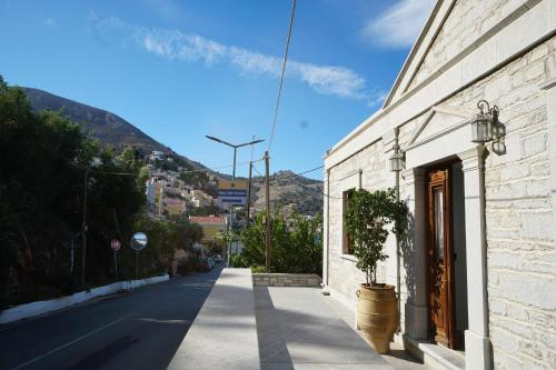 an empty street with a building and a potted plant at Petalo House in Symi