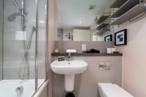 uma casa de banho com um lavatório, um chuveiro e um WC. em 2 bedroom apartment in London Bridge em Londres