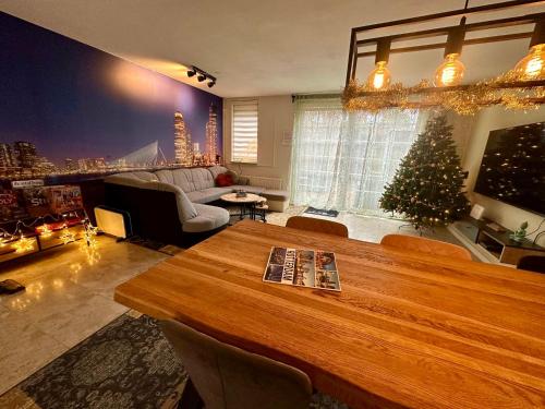 een woonkamer met een kerstboom en een tafel bij Rotterdam Citytrip House in Rotterdam