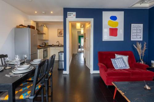 a living room with a red couch and a dining table at SEA HEIGHTS MARGATE in Margate