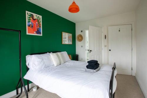 a green bedroom with a white bed with a green wall at SEA HEIGHTS MARGATE in Margate