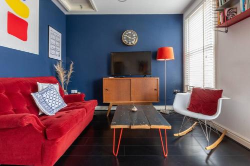 a living room with a red couch and a tv at SEA HEIGHTS MARGATE in Margate