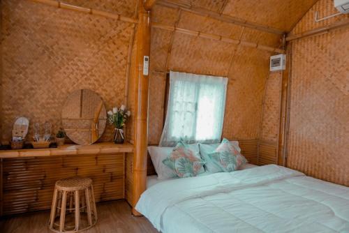 a bedroom with a bed and a mirror and a window at ชีวาวิลล์ ฟาร์มสเตย์ - Cheewavill farmstay in Ban Ko