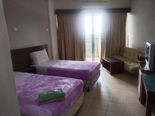 ein Hotelzimmer mit 2 Betten und einem Sofa in der Unterkunft JANAVIEW CONDOTEL 2 in Taiping