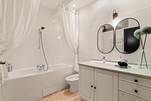 La salle de bains blanche est pourvue d'une baignoire, de toilettes et d'un lavabo. dans l'établissement Nice - Renting - LASCARIS - Charm & Spacious & Comfort 3P Port Bonaparte, à Nice