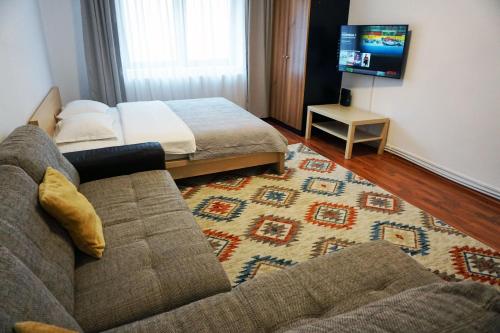 a living room with a couch and a bed at Apartament Viva Predeal in Predeal