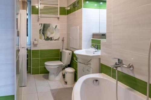 a bathroom with a toilet and a sink and a tub at Sunny apartment in Trnava in Trnava