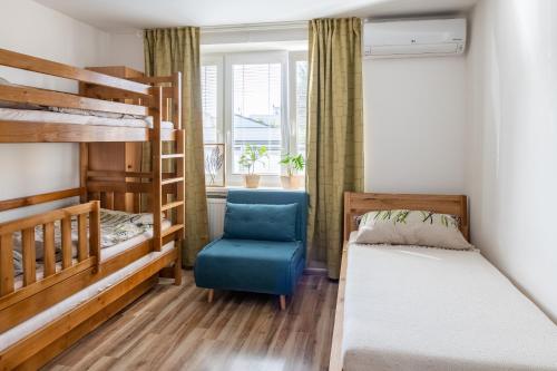 a bedroom with two bunk beds and a blue chair at Sunny apartment in Trnava in Trnava