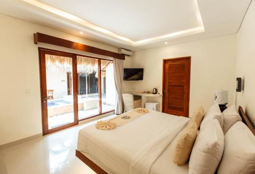 a bedroom with a bed and a large window at La Bella - Hotel Villa & Spa in Gili Trawangan