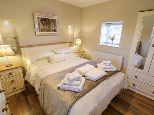 a bedroom with a bed with towels on it at Lough Island Reavy Cottage in Newry