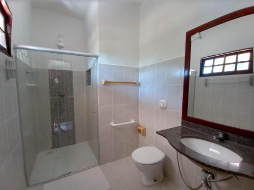 uma casa de banho com um chuveiro, um WC e um lavatório. em Pousada Cheiro de Mar em Nova Viçosa