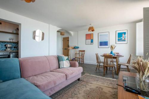 a living room with a pink couch and a table at Stunning Sea Views @ The Lido Lounge in Margate