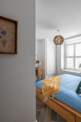 a bedroom with a bed with blue sheets and a window at Stunning Sea Views @ The Lido Lounge in Margate