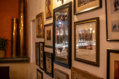 a wall filled with framed pictures on a wall at The Sun House in Galle