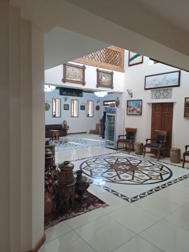 a large room with a lobby with a table and chairs at Devon Begi Heritage Hotel in Bukhara
