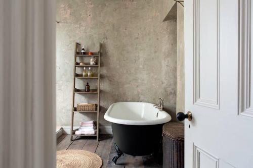 a bathroom with a bath tub and a sink at Trinity Square Georgian Townhouse in Margate