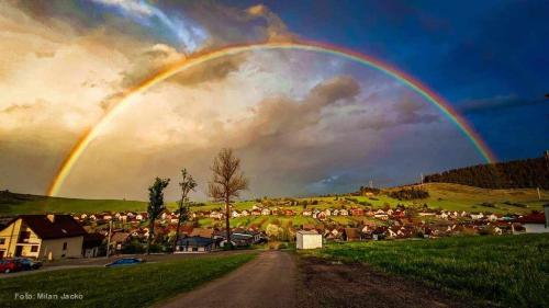 a rainbow in the sky over a town at Deluxe Apartman Lara in Liptovské Sliače
