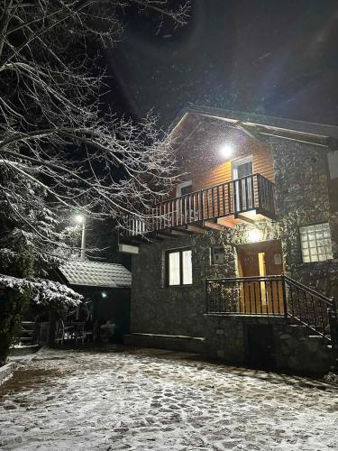 Una casa en la nieve por la noche en Villa Albani, en Peje