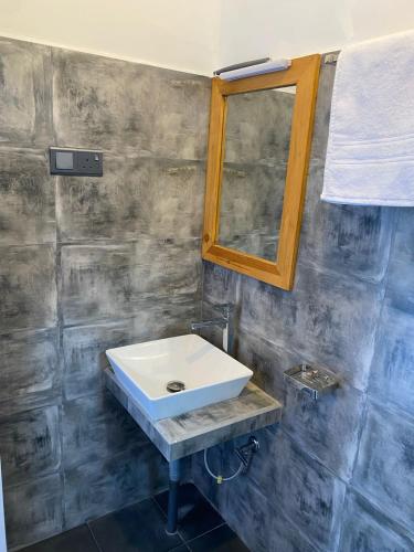 a bathroom with a white sink and a mirror at Reefline Villa in Weligama