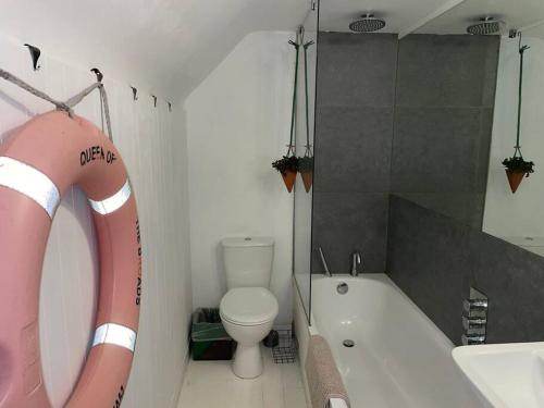 a bathroom with a bath tub and a toilet and a bath tub at Turner Cottage - 3 bed with a View of the Harbour in Margate