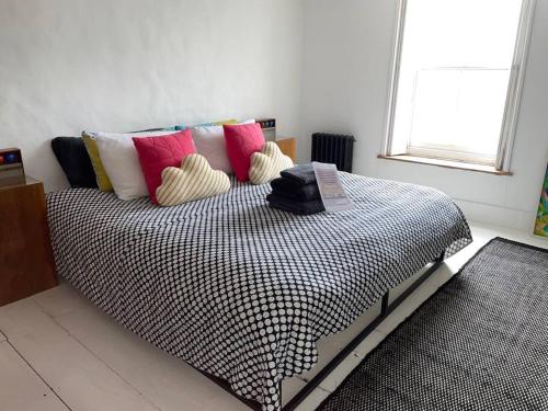 a bedroom with a bed with pillows and a window at Turner Cottage - 3 bed with a View of the Harbour in Margate