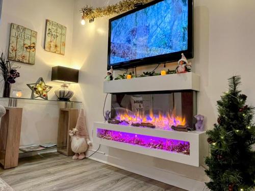 a living room with a fish tank and a tv at Hayloft at Bonnyside House in Bonnybridge