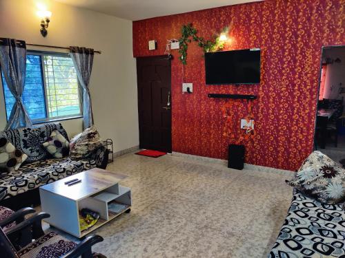 a living room with a red wall at Venus Villa in Panchgani