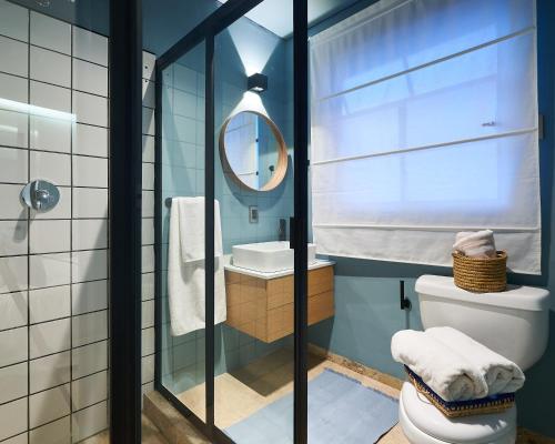 a bathroom with a toilet and a mirror at AmazINN Places La Condesa Roma in Mexico City