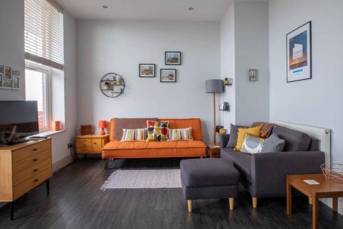 a living room with a couch and a chair at Waves@Walpole - 2 Bed Flat with Amazing Sea Views in Margate