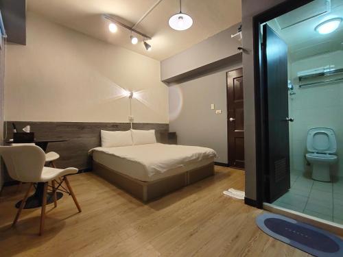 a bedroom with a bed and a bathroom with a toilet at 駐典Txg in Taichung
