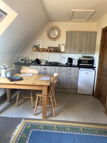 a kitchen with a wooden table and a white refrigerator at Robeanne House in Shiptonthorpe