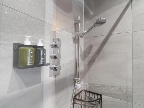 a shower with a soap dispenser on a wall at Dovedale in Ashbourne