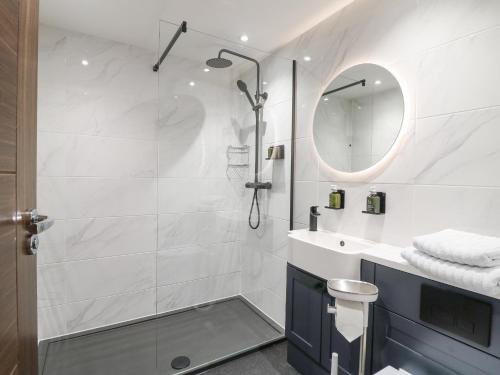 a bathroom with a shower and a sink and a mirror at Monsal Dale in Ashbourne