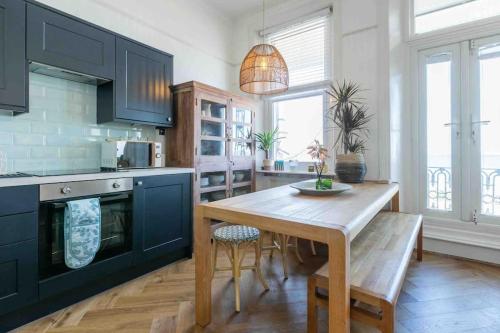 uma cozinha com uma mesa de madeira e armários azuis em The Terrace At Westbrook - Pet friendly em Margate