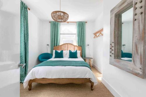 um quarto com uma cama com almofadas azuis e um espelho em The Terrace At Westbrook - Pet friendly em Margate