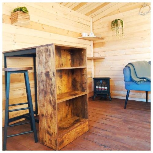 a wooden cabin with a book shelf and a chair at La Casina in Trecasali