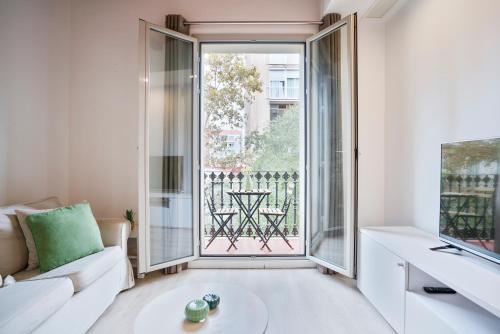 - un salon avec un canapé et une grande fenêtre dans l'établissement BcnStop Sant Pau Suites, à Barcelone