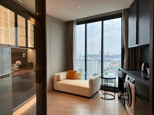 a living room with a couch and a kitchen with a view at 502 Edge芭提雅市中心25楼高层海景服务公寓，芭提雅海湾景观，近沙滩，步行街，购物中心 in Pattaya