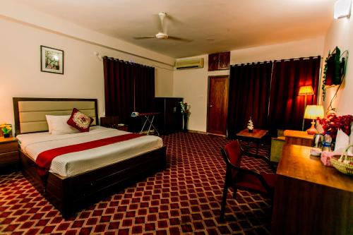 um quarto de hotel com uma cama e uma secretária em GR MEET & GREET em Dhaka