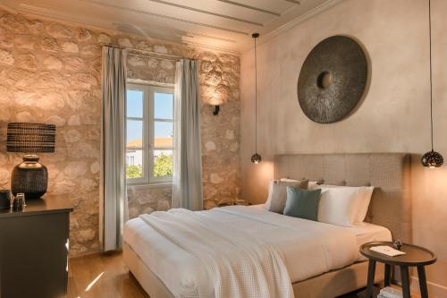a bedroom with a large bed and a window at Hydroussa Hotel Hydra in Hydra