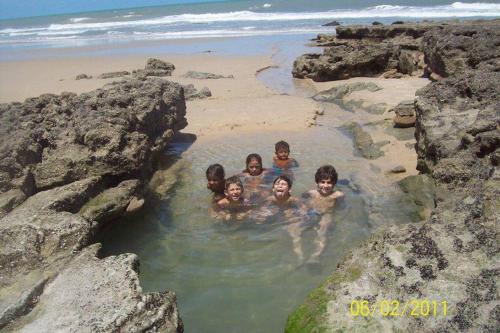 a group of children swimming in a pool on the beach at Pousada A Vida é Bela in Águas Belas